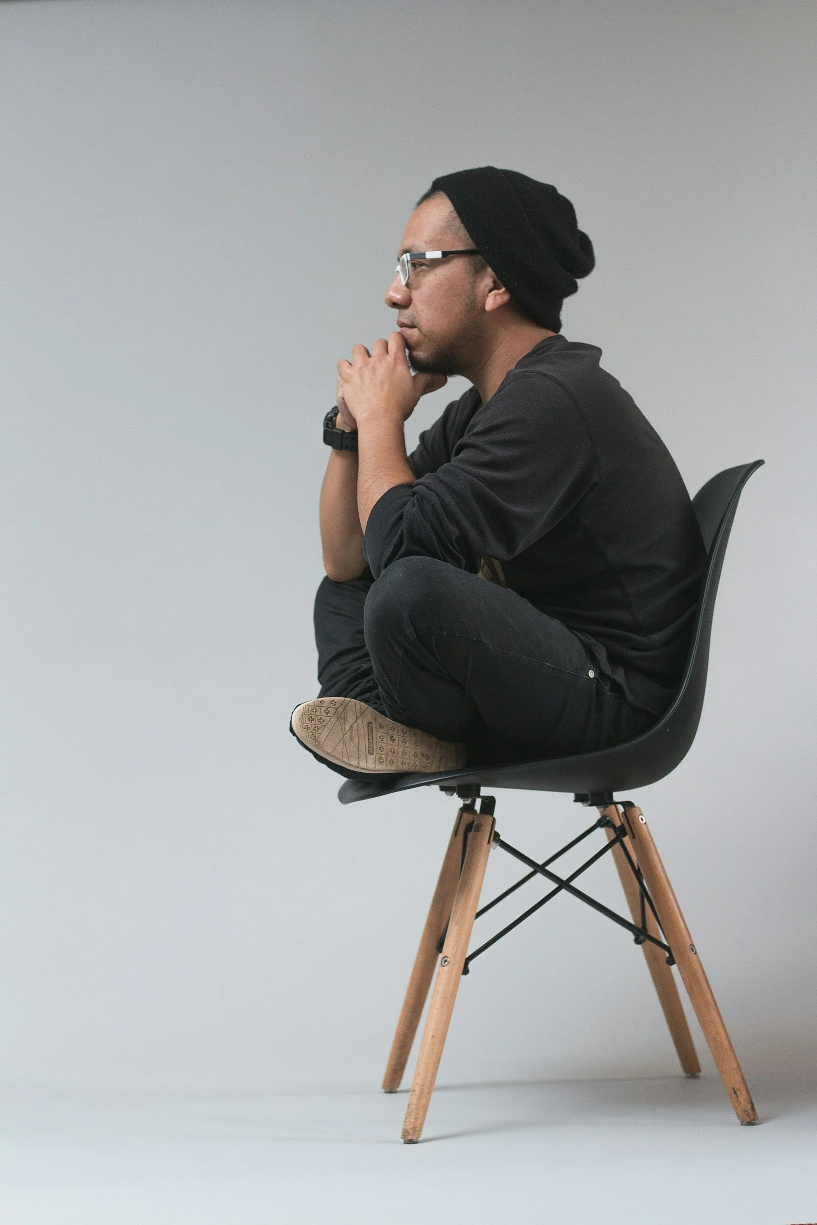 Person sits cross-legged in a chair in contemplation.