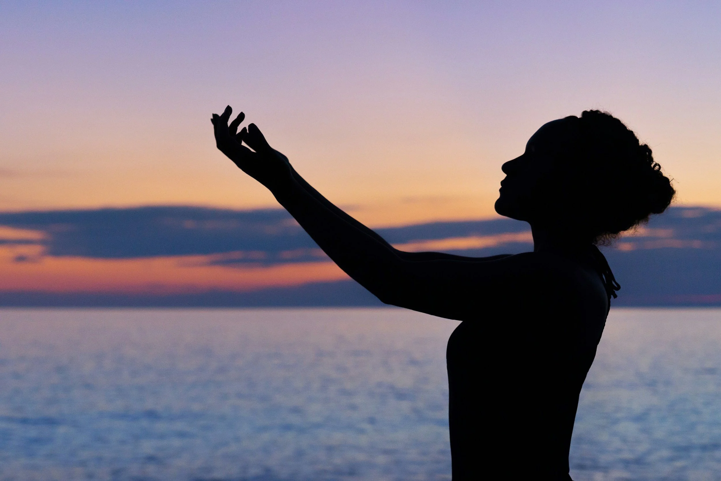 Silhouette of a woman at sunset on a beach.